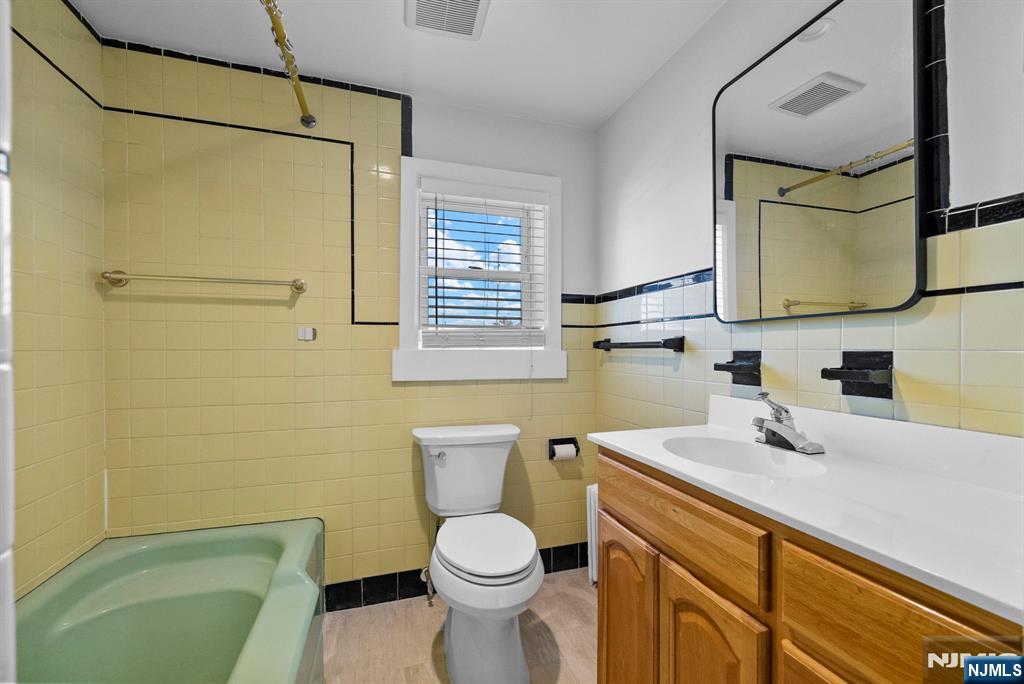 461 9th Street, Unit 2 Fairview, NJ 07022 - Photo 15 of 19 a bathroom with a sink a toilet and mirror
