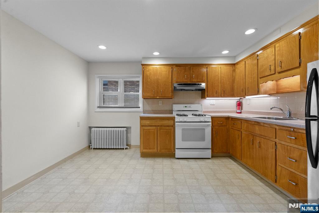 461 9th Street, Unit 2 Fairview, NJ 07022 - Photo 5 of 19 a kitchen with a sink window and stainless steel appliances