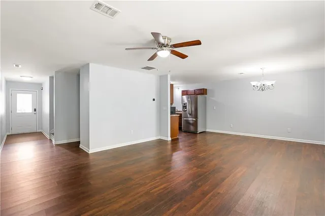 a view of empty room with wooden floor