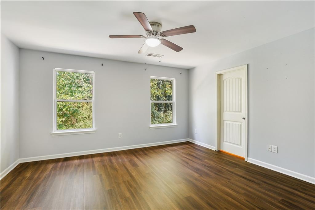 1221 Rockfield Circle Norcross, GA 30093 - Photo 5 of 10 a view of an empty room with wooden floor and a window