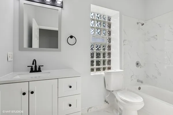 a bathroom with a granite countertop sink toilet a mirror and shower