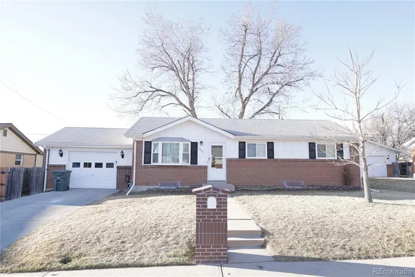 a front view of a house with a yard covered in snow