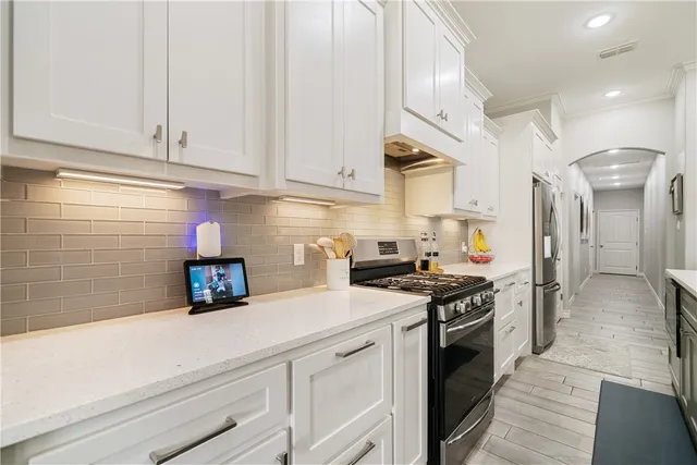 a kitchen with stainless steel appliances granite countertop a sink a stove and a refrigerator