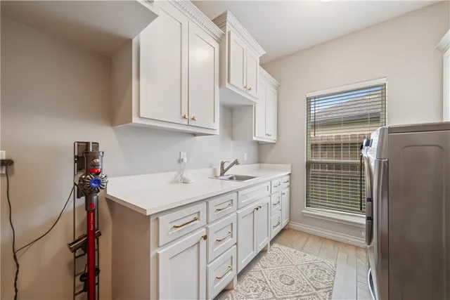 a utility room with cabinets washer and dryer