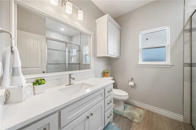 a bathroom with a sink a toilet and a mirror