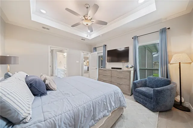 a bedroom with a bed a flat screen tv and a couch