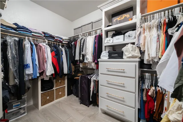 a view of walk in closet with clothes and shoes
