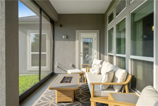 a dining room with furniture and a floor to ceiling window