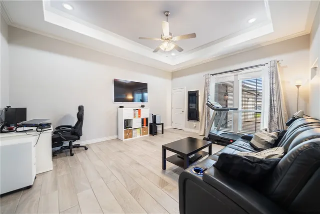 a living room with furniture flat screen tv and a ceiling fan