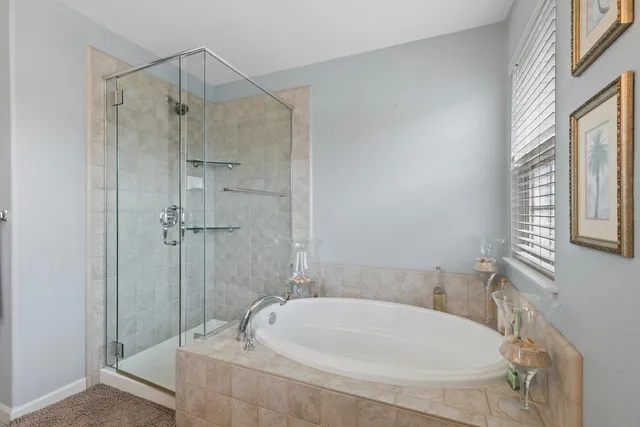 a bathroom with a tub shower and window