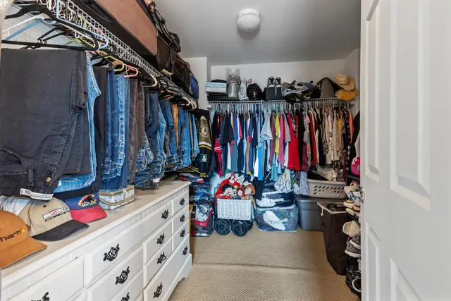 a view of walk in closet with clothes