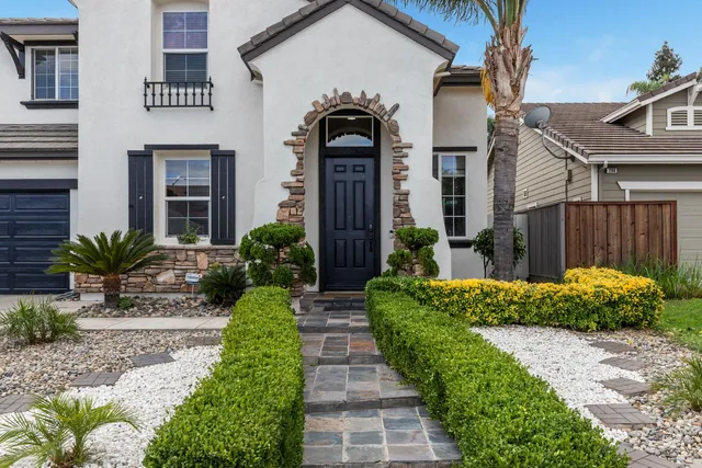 a front view of a house with a garden