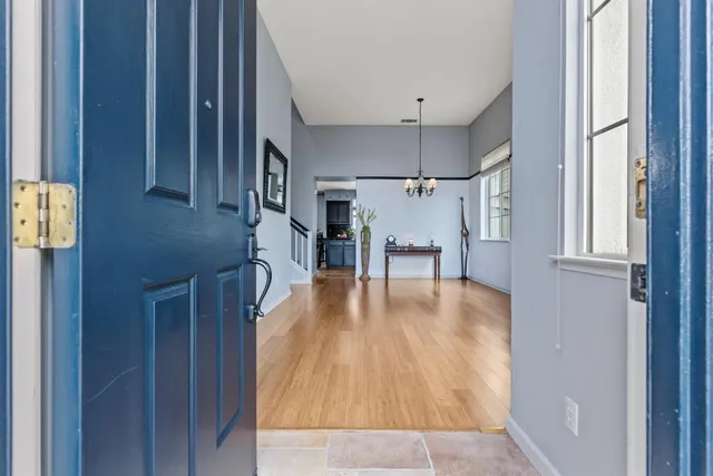 a hallway with wooden floors with table and chairs