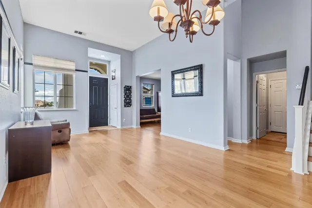 a view of a livingroom with a dinning area hardwood floor and a ceiling fan