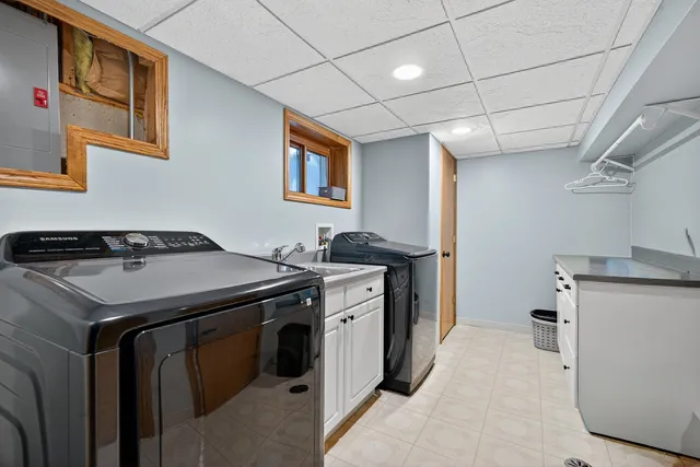 a utility room with cabinets washer and dryer
