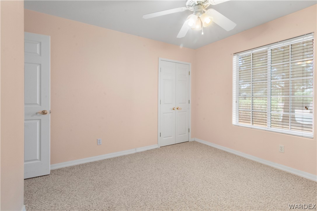 2158 Ranch Road Kingman, AZ 86401 - Photo 24 of 48 an empty room with a window and a ceiling fan