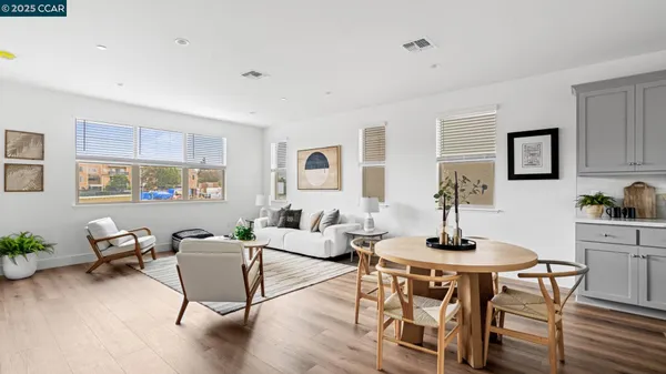 a living room with furniture a table and wooden floor