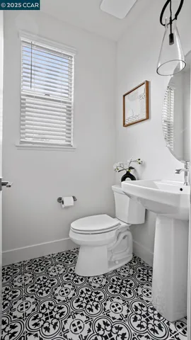 a bathroom with a sink a toilet and a window