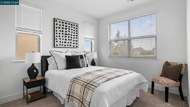 a bedroom with a bed chairs and a window