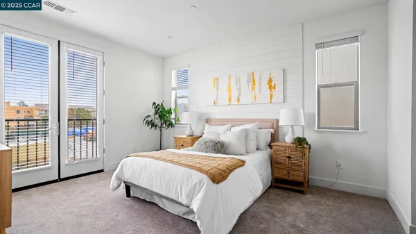 a bedroom with a bed a dresser and a large window