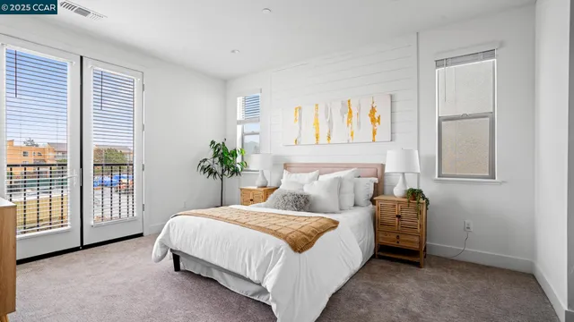 a bedroom with a bed a dresser and a large window