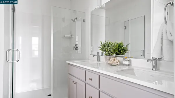 a bathroom with a granite countertop sink a mirror and a shower