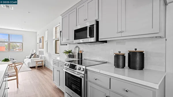 a kitchen with stainless steel appliances granite countertop a sink a stove a microwave and wooden cabinets