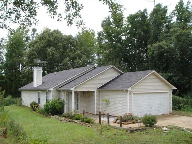 121 Floyd Road Newnan, GA 30263 - Photo 1 of 1 a view of a yard in front of a house with plants and large tree