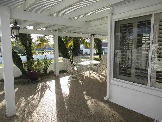 a view of a porch with chairs and potted plants