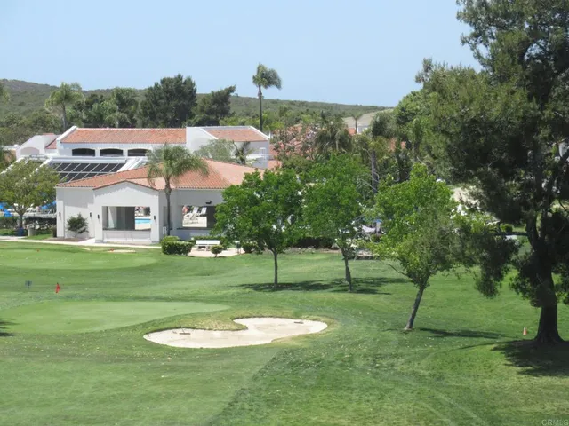 a view of a big house with a big yard and large trees