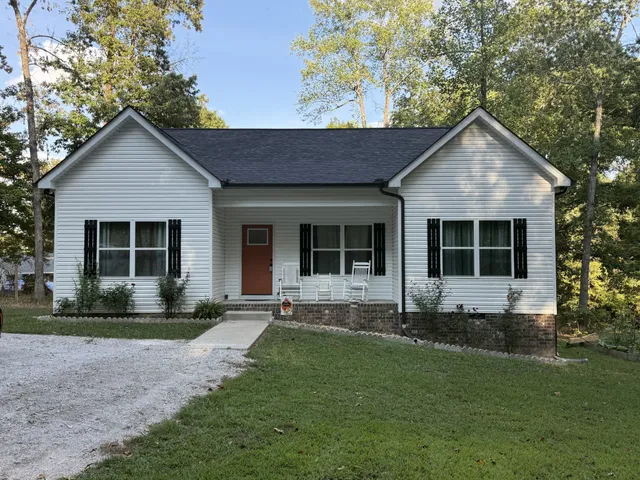 a front view of a house with a yard and outdoor seating