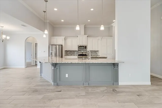 a kitchen with stainless steel appliances granite countertop a sink refrigerator and microwave