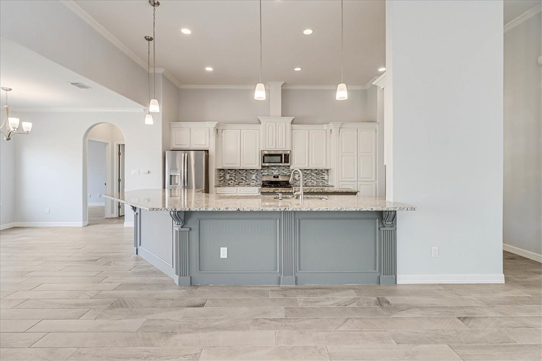 15501 Escapade Street Corpus Christi, TX 78418 - Photo 11 of 40 a kitchen with kitchen island a sink stainless steel appliances and cabinets