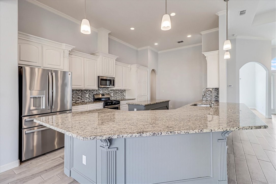 15501 Escapade Street Corpus Christi, TX 78418 - Photo 12 of 40 a kitchen with stainless steel appliances granite countertop a sink refrigerator and microwave
