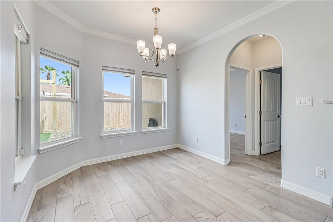 15501 Escapade Street Corpus Christi, TX 78418 - Photo 15 of 40 an empty room with wooden floor chandelier and windows