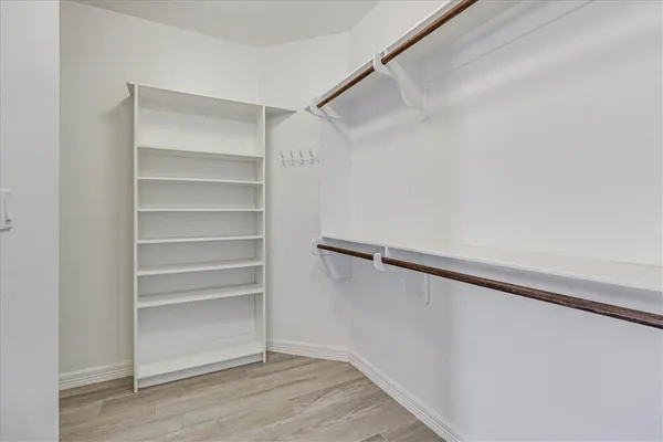 a view of a hallway with closet and wooden floor