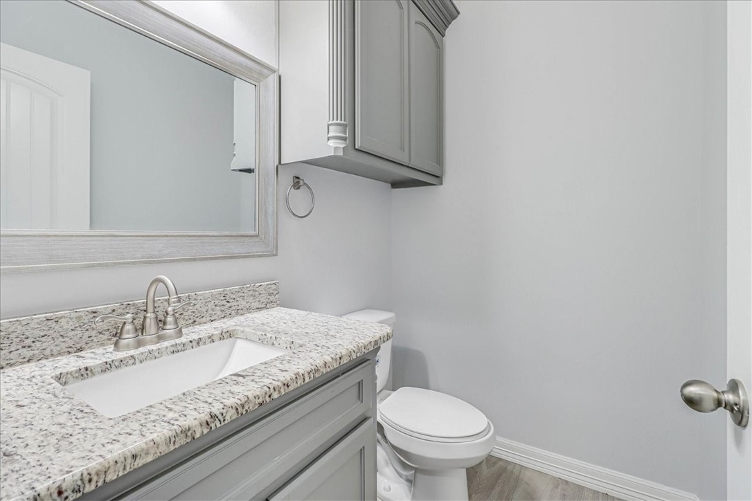 15501 Escapade Street Corpus Christi, TX 78418 - Photo 36 of 40 a bathroom with a granite countertop sink and a toilet