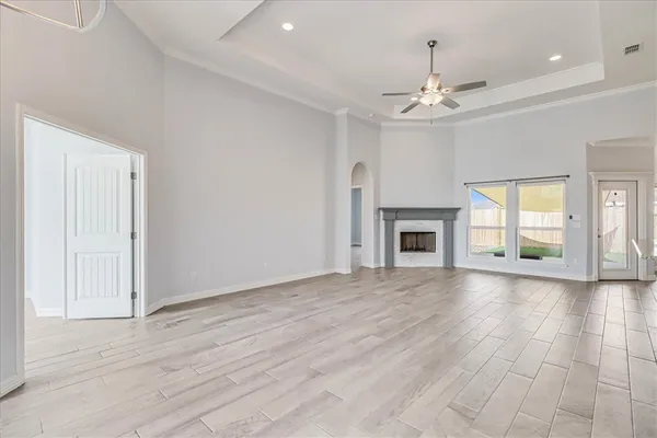 a large kitchen with stainless steel appliances a large counter top a refrigerator and a chandelier