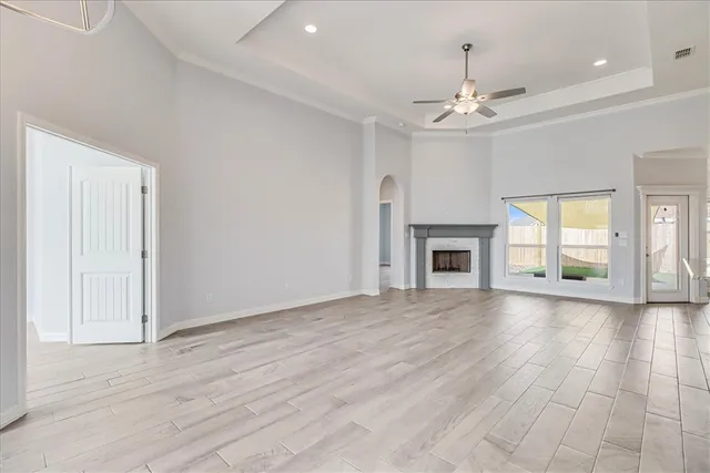 a large kitchen with stainless steel appliances a large counter top a refrigerator and a chandelier