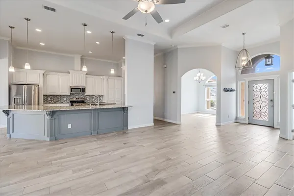 a kitchen with kitchen island a sink stainless steel appliances and cabinets