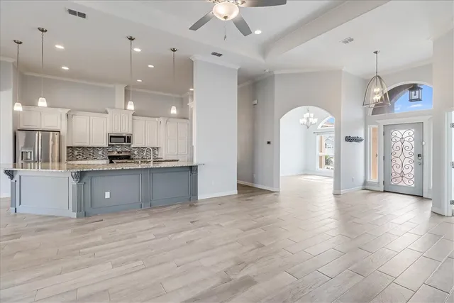 a kitchen with kitchen island a sink stainless steel appliances and cabinets