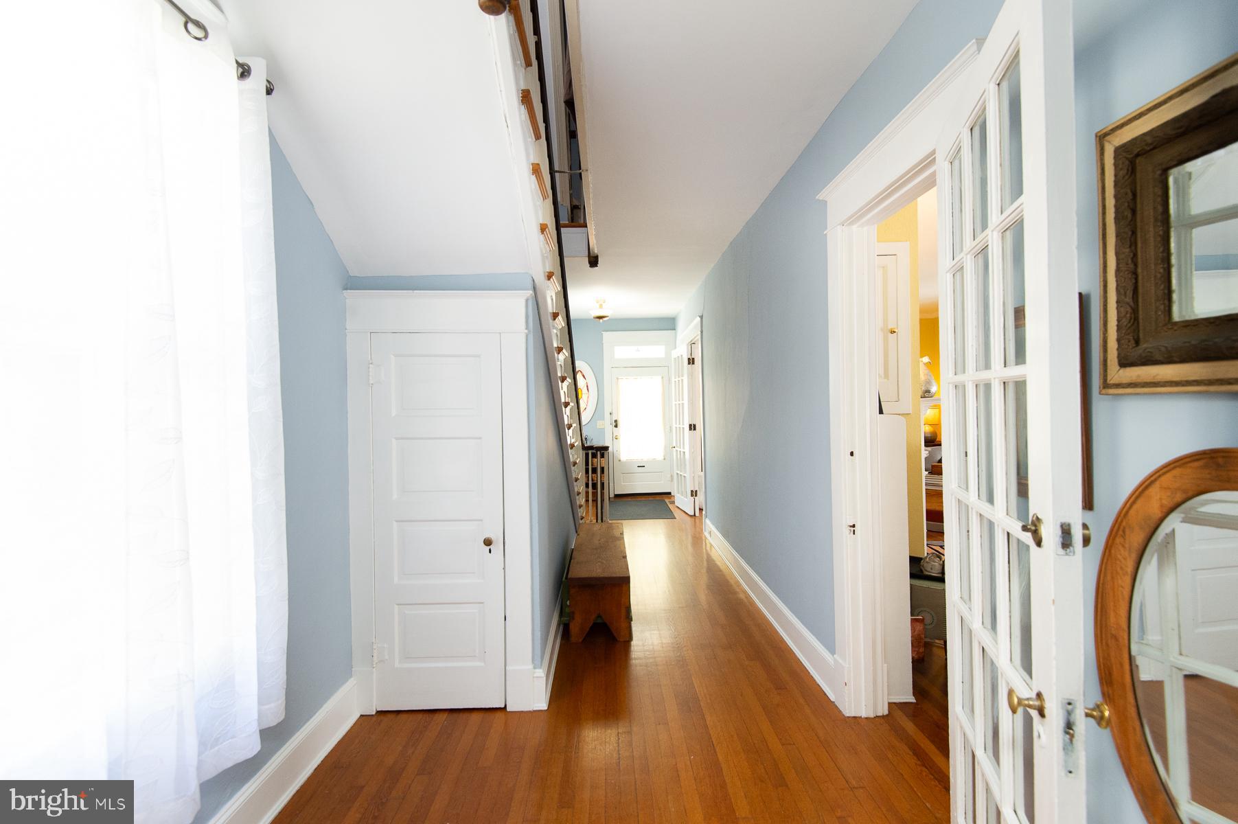 606 Locust Street Cambridge, MD 21613 - Photo 7 of 37 a view of a hallway with wooden floor and staircase