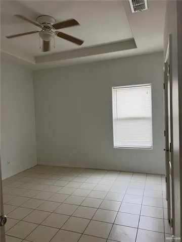 an empty room with a ceiling fan and window