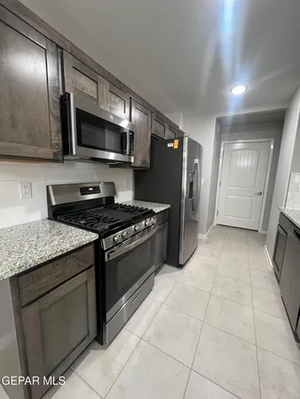 a kitchen with stainless steel appliances granite countertop a stove a microwave and a sink