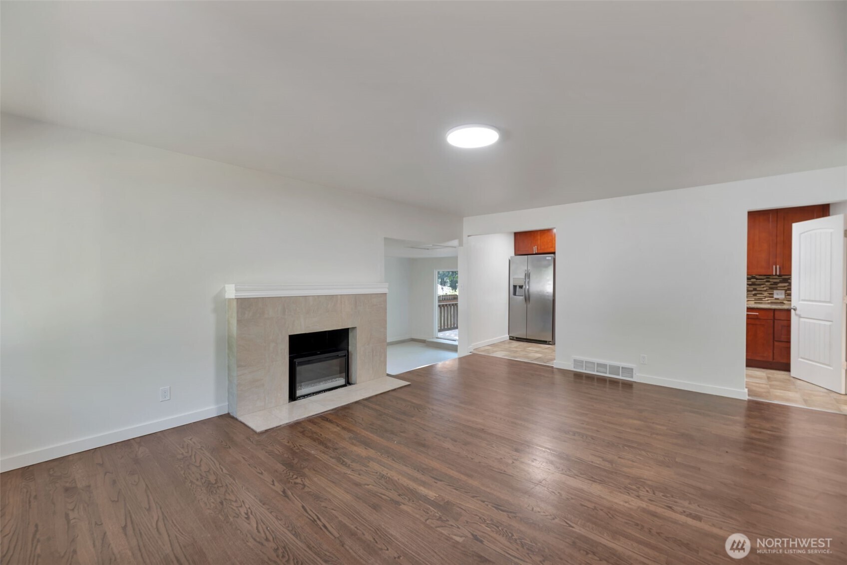 11229 29th Avenue Southwest Seattle, WA 98146 - Photo 3 of 28 a view of an empty room with wooden floor and fireplace
