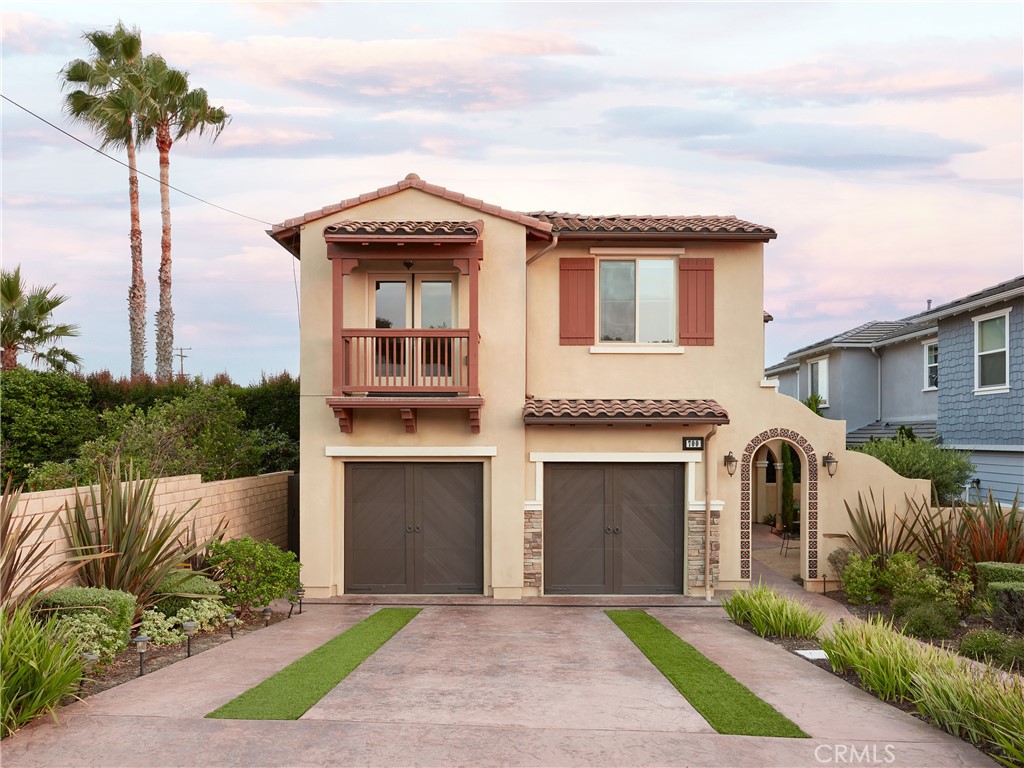 a front view of a house with a garden and trees