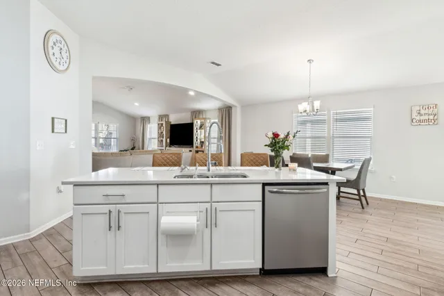 a view of a dining room with furniture a kitchen and chandelier