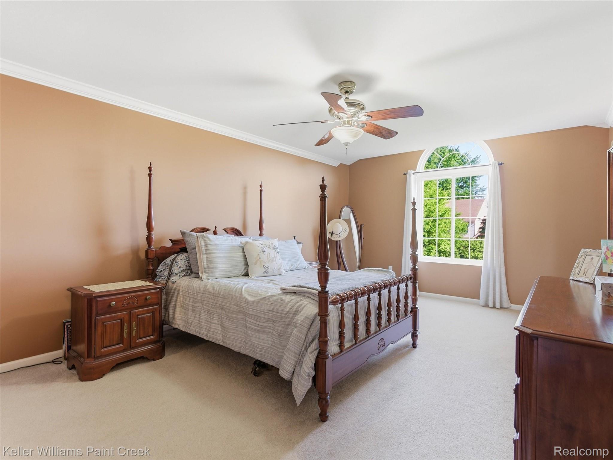2842 Manorwood Road Troy, MI 48085 - Photo 45 of 72 Spacious room featuring neutral carpeting, a large arched window, a ceiling fan with integrated lighting, and crown molding