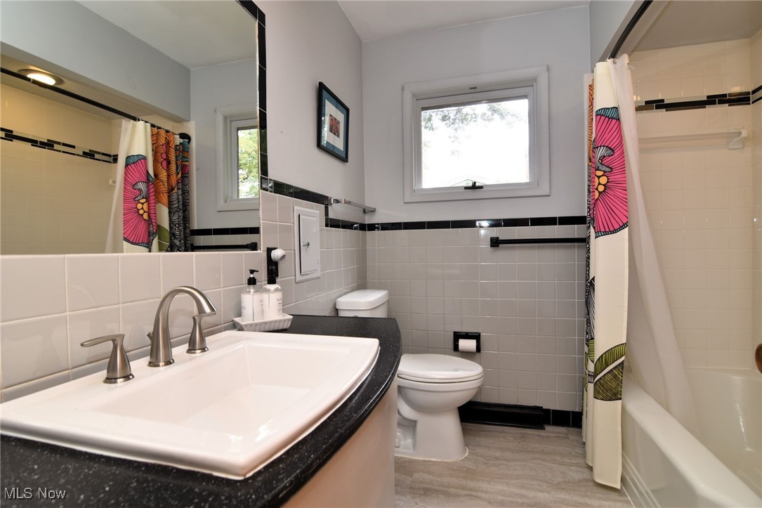 2071 Wyndham Road Akron, OH 44313 - Photo 26 of 42 Full bathroom featuring shower / bath combo, vanity, tile walls, and toilet.