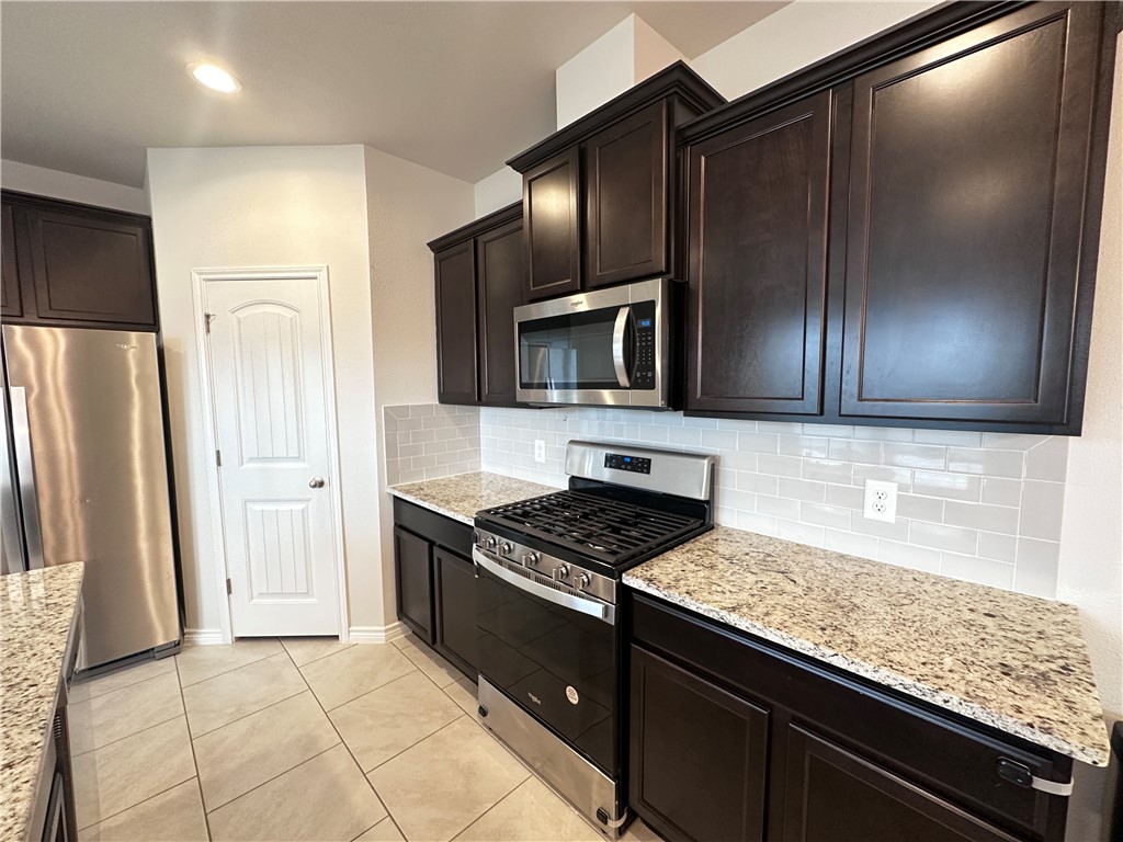 7649 Herd Rider Lane Corpus Christi, TX 78414 - Photo 3 of 18 a kitchen with granite countertop stainless steel appliances and wooden cabinets